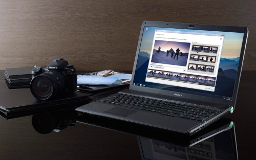 Ноутбук и фотоаппарат лежат на столе