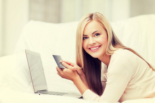 Красивая девушка, ноутбук и кредитная карта