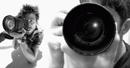 Парень фотографирует на зеркальную фотокамеру