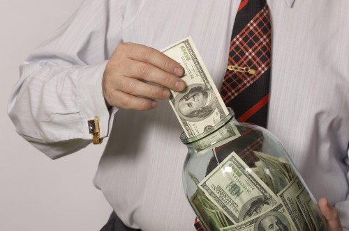 Мужчина вкладывает деньги в банку