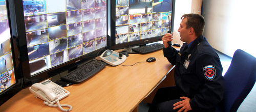 Охранник сидит за пультом управления