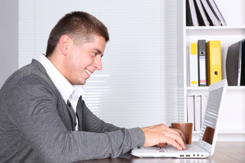 Парень сидит напротив ноутбука