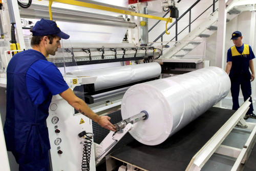 Рабочие в цеху производят полиэтиленовую плёнку