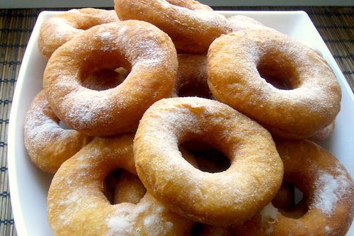 Пончики посыпанные пудрой в тарелке