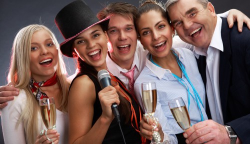 Девушки и парни на празднике с бокалами шампанского в руках