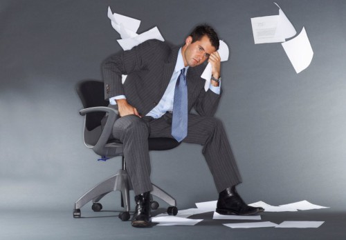 Начинающий бизнесмен сидит на стуле и думает об ошибках, которые совершил