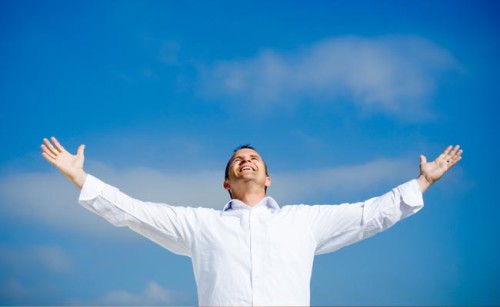 Мужчина стоит подняв руки вверх