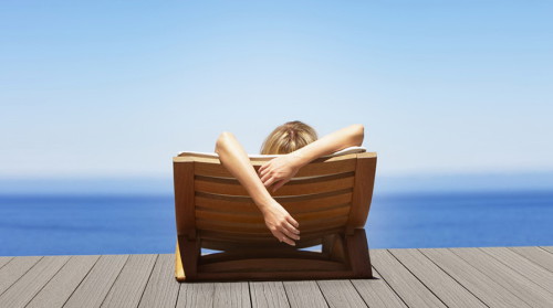 Девушка лежит на море в шезлонге